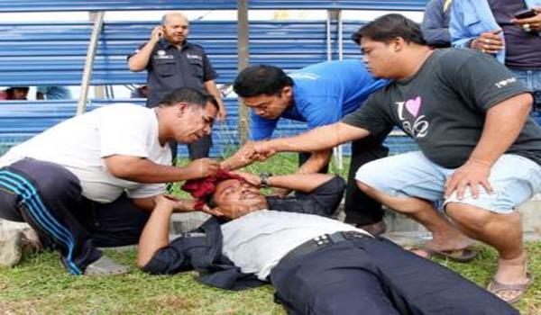 Orang awam membantu seorang anggota polis yang cedera akibat dipukul oleh penjenayah yang melarikan diri